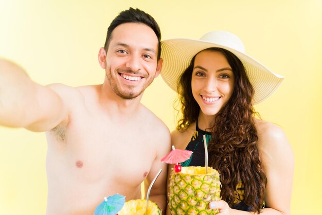 Point de vue personnel d'un beau couple de jeunes mariés prenant un selfie tout en profitant de leurs vacances à la plage. Couple postant une photo sur les réseaux sociaux