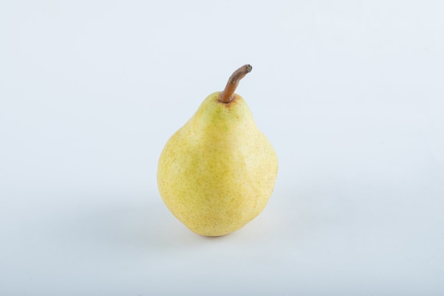 Poire jaune mûre sur blanc.