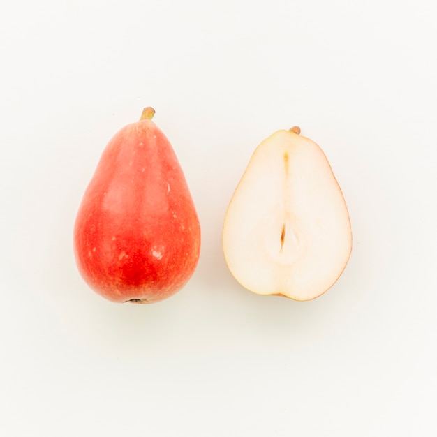 Photo gratuite poire rouge juteuse et coupée en deux