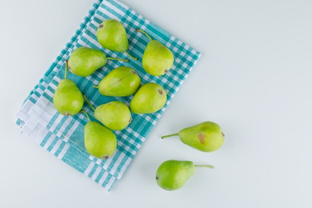 Poires fraîches sur fond blanc et torchon de cuisine. pose à plat.