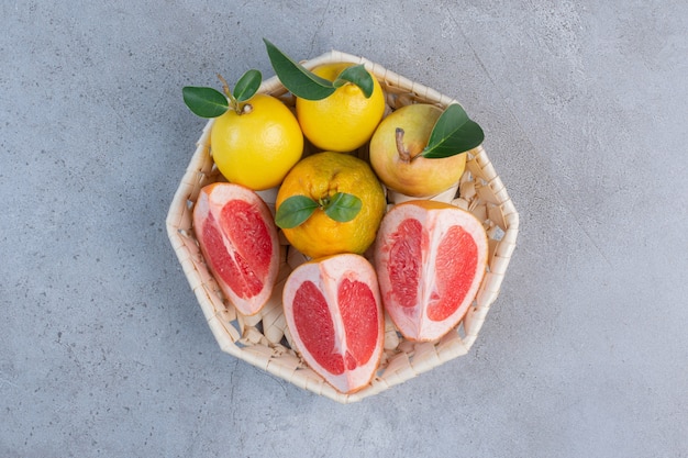 Poires Et Tranches De Pamplemousse Dans Un Panier Blanc Sur Fond De Marbre.