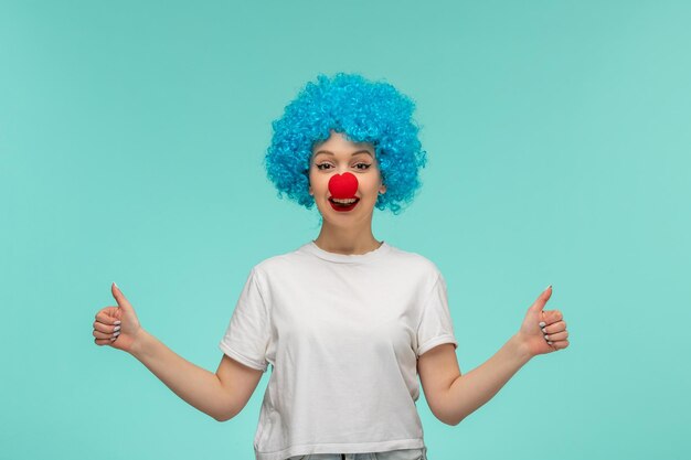 Poisson d'avril happy smiley girl très bonnes mains geture avec nez rouge en costume de clown cheveux bleus