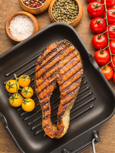 Poisson grillé avec vue de dessus de tomates