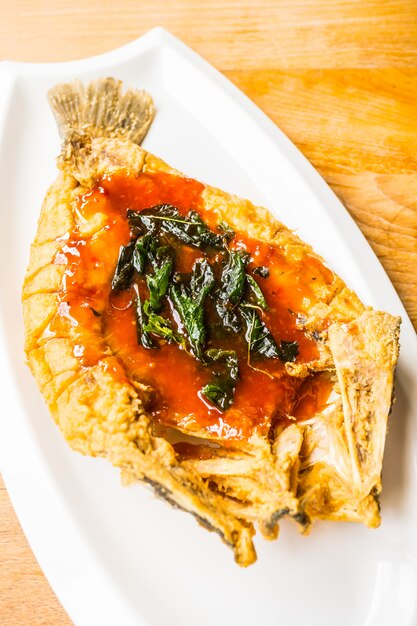 Poisson de mer de frit au plat blanc avec sauce épicée et sucrée