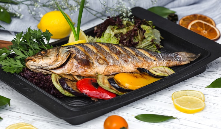 Photo gratuit poisson rôti garni de rondelles de citron et de légumes
