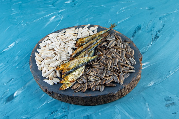 Poisson séché et noyau sur une planche, sur la surface bleue.