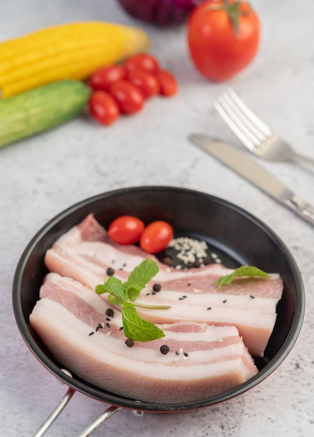 Poitrine de porc dans une poêle avec des graines de poivron Tomates et épices