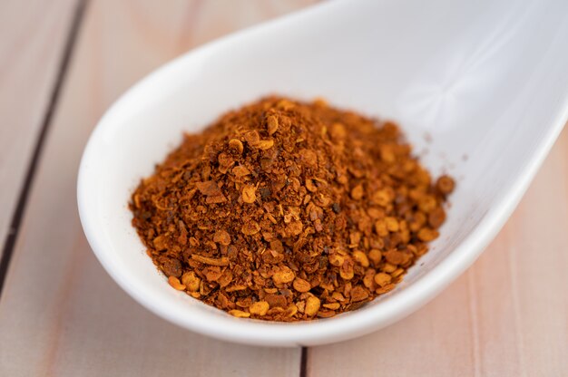 Poivre de Cayenne dans une tasse sur le plancher en bois.