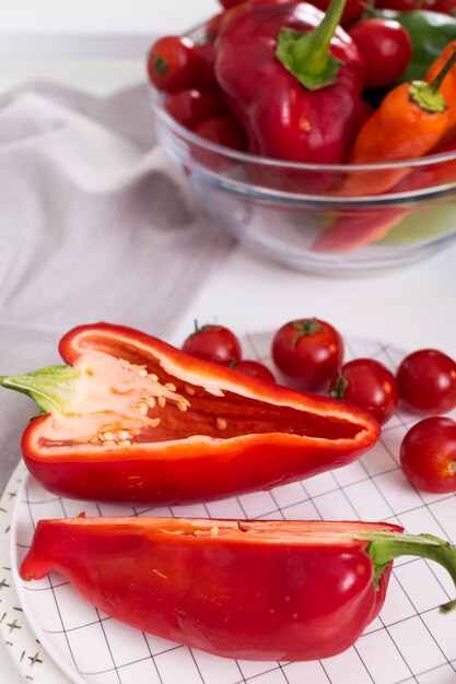 Poivron rouge coupé en deux et tomates cerises sur plaque