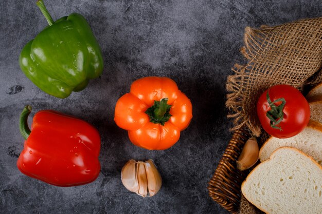 Poivrons, ail et tomates avec des tranches de pain.