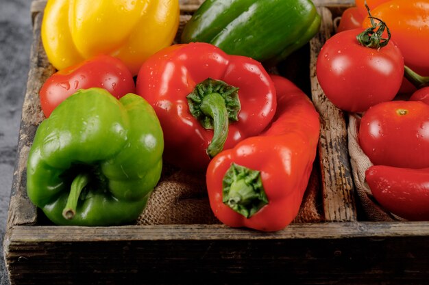 Poivrons de couleur dans le récipient en bois.