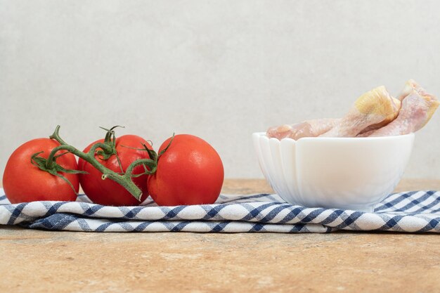 Poivrons avec cuisses de poulet cru sur nappe