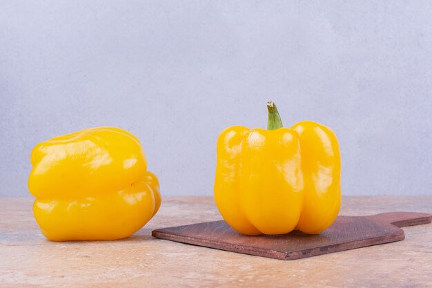 Poivrons isolés sur un plateau en bois sur le marbre