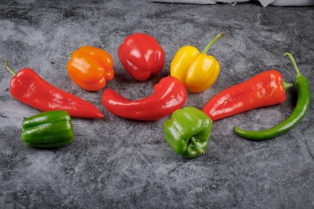 Photo gratuite poivrons et piments colorés sur le marbre gris.