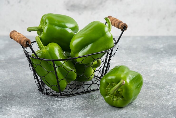 Photo gratuit poivrons verts dans un panier métallique sur table en marbre.