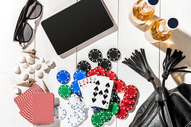 Poker. Prêt à jouer au poker avec des cartes et des jetons sur une table en bois blanche, vue de dessus. Copier l'espace