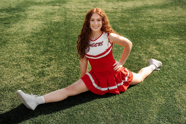 Pom-pom girl pleine de coups faisant le grand écart