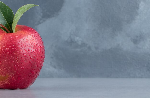 Une pomme délicieuse affichée sur du marbre.