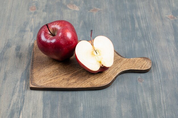 Pomme fraîche rouge sur planche de bois