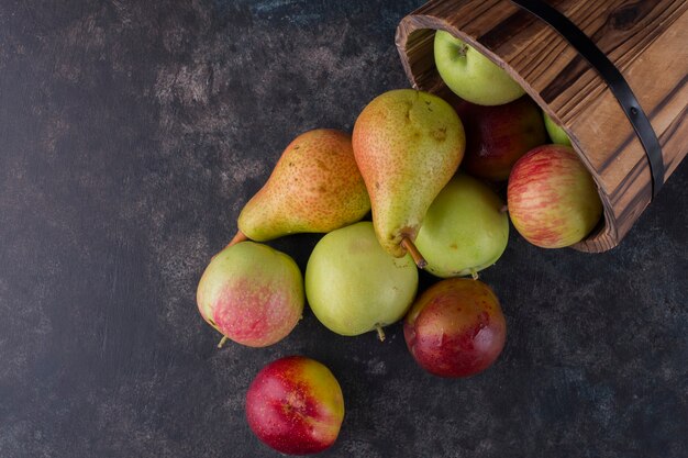 Pomme, pêche et poires dans un seau en bois