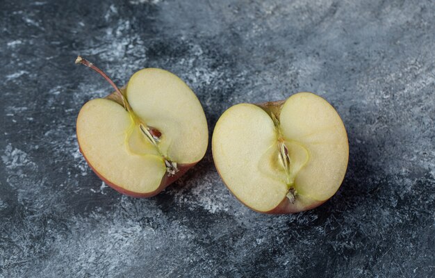 Pomme rouge fraîche tranchée sur fond de marbre.