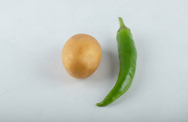 Pomme de terre fraîche et poivron vert sur fond blanc.