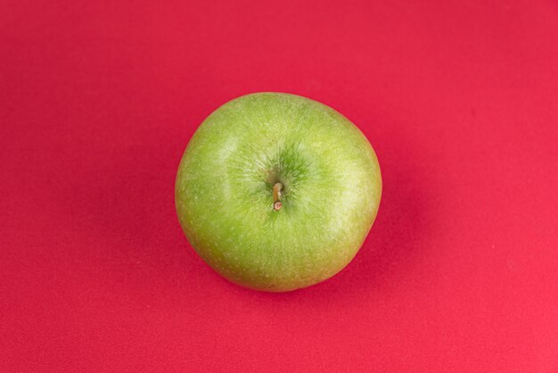Pomme verte sur fond rouge