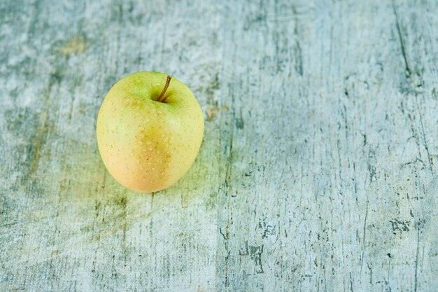 Pomme verte juteuse fraîche isolée sur fond de marbre.