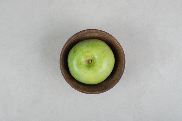 Pomme verte savoureuse dans un bol en bois