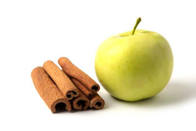 Pomme verte et un stock de bâtons de cannelle