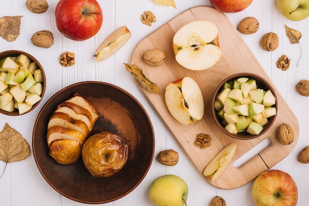 Photo gratuite pommes assorties près des noix et des feuilles