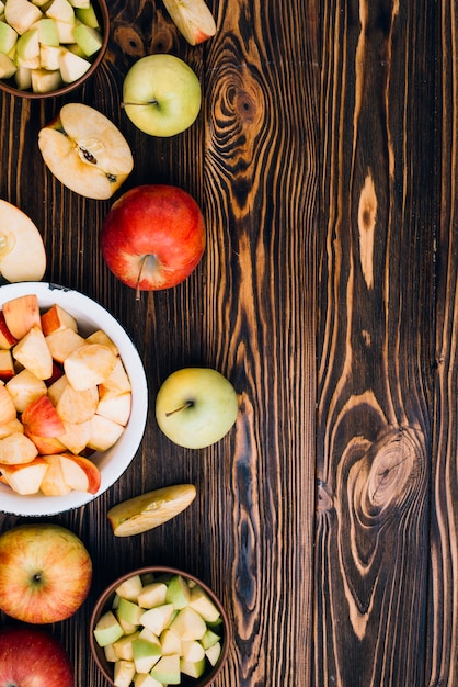 Photo gratuite pommes coupées et entières sur table en bois