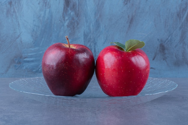 Pommes à croquer sur une plaque de verre sur la surface sombre