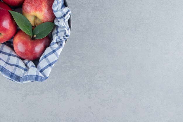 Pommes enveloppées dans une serviette sur du marbre.