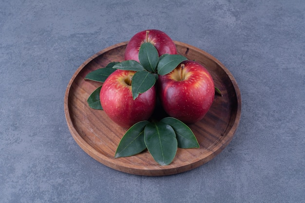 Pommes et feuilles au tableau sur table en marbre.