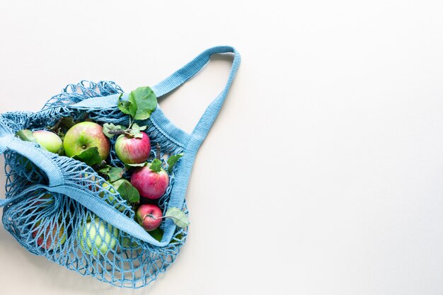 Pommes fraîches dans un filet de sac à provisions. Zéro déchet, pas de concept plastique. Une alimentation saine et détox. Récolte d'automne. Mise à plat, vue de dessus.