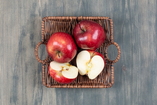 Pommes fraîches rouges dans un panier en bois