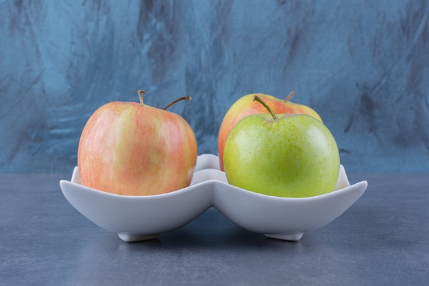 Photo gratuite pommes fraîches sucrées dans une assiette, sur la surface sombre