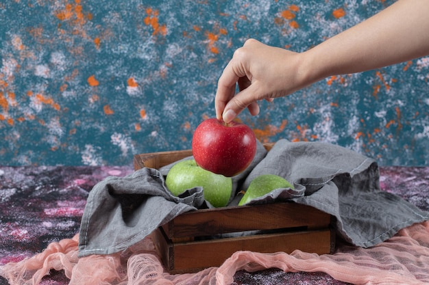 Pommes sur plateau en bois rustique sur texturé.