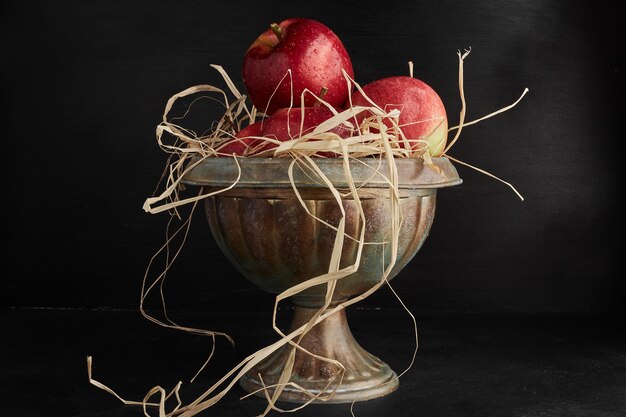 Pommes rouges dans une tasse métallique.