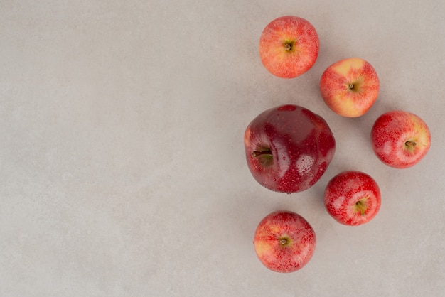 Pommes rouges et fraîches sur tableau blanc.