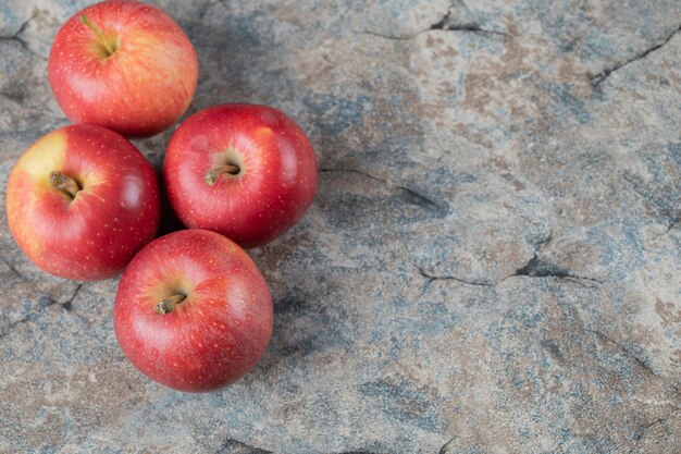 Pommes rouges isolées sur béton.