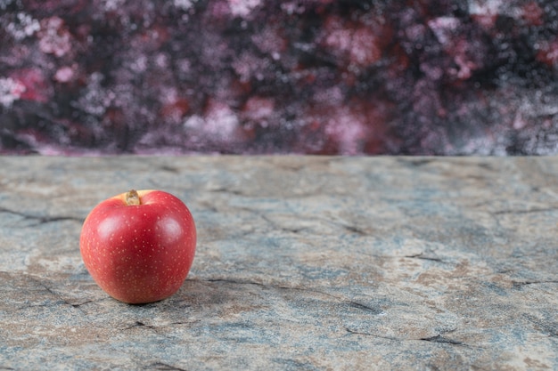 Pommes rouges isolés sur une surface en béton