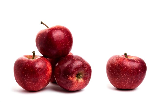 Pommes rouges savoureuses isolées sur blanc.