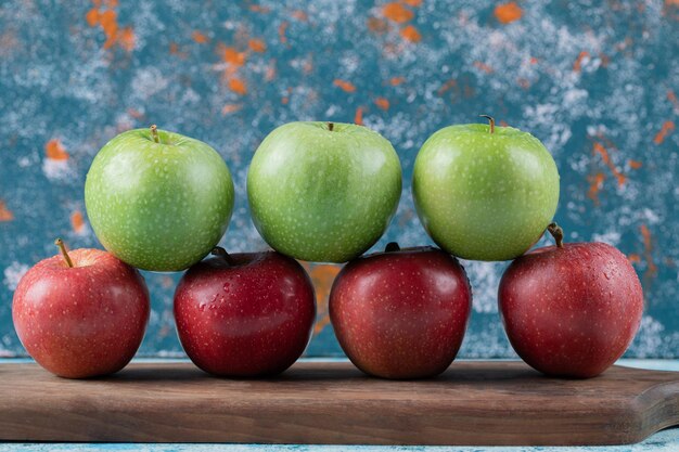 Photo gratuite pommes rouges et vertes isolées sur planche de bois.