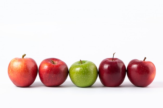 Pommes rouges et vertes moelleuses juteuses sur un bureau blanc