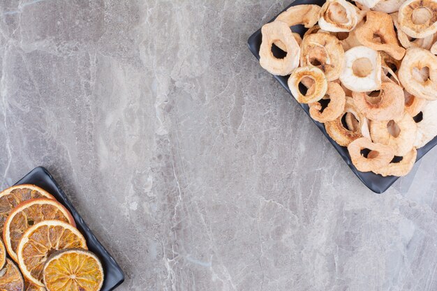 Pommes saines séchées sur assiette sombre.