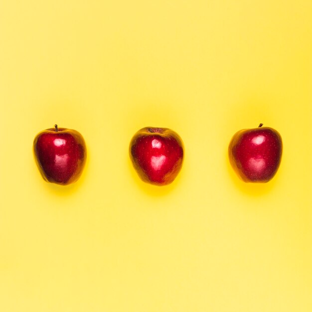 Pommes savoureuses brillantes rouges sur fond blanc