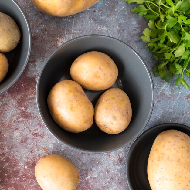 Pommes de terre crues dans un bol gris