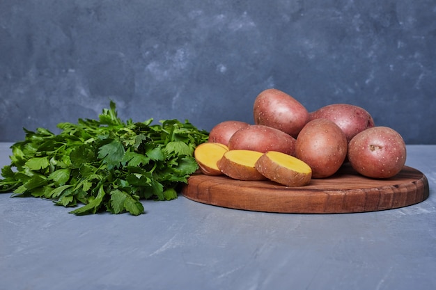 Photo gratuite pommes de terre et herbes sur bleu